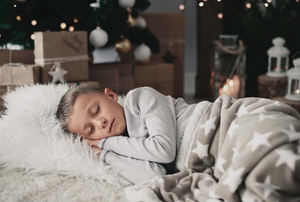 Un enfant dormant paisiblement sous un ciel étoilé, illustrant l'apaisement des terreurs nocturnes par l'hypnose.